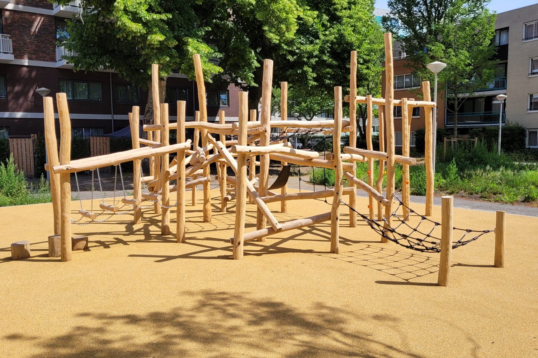 Houten klimtoestel met touwbruggen in woonwijk
