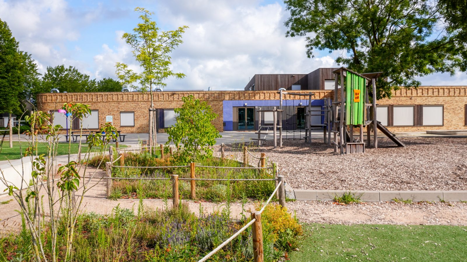 Houten speeltoestellen voor een groenblauw en vitaal schoolplein